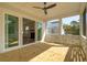 The covered porch overlooks the backyard, featuring ceiling fan, sliding glass doors and white railings at 3683 Nassas St, Mount Pleasant, SC 29466