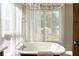 Clawfoot bathtub with vintage faucet against sunny sheer curtain-covered window at 40 Dunnemann Ave, Charleston, SC 29403