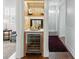 This wet bar features wooden accents, shelving, a beverage refrigerator, and a white countertop for a modern and stylish look at 44 Savage St, Charleston, SC 29401