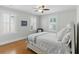 Bright bedroom features hardwood floors, ceiling fan, and three windows with white shutters at 44 Savage St, Charleston, SC 29401