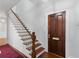 Inviting entryway with a wooden staircase, hardwood floors, white trim, and a classic door creating a warm welcome at 44 Savage St, Charleston, SC 29401