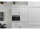 This modern kitchen boasts custom white cabinetry and a stainless steel built-in Wolf coffee maker for gourmet convenience at 44 Savage St, Charleston, SC 29401
