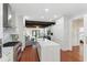 Modern kitchen with white cabinets, stainless steel appliances, marble backsplash, and an island with hardwood floors for a sleek design at 44 Savage St, Charleston, SC 29401