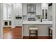 Modern kitchen featuring white cabinets, a marble backsplash, stainless steel appliances, and a central island with seating at 44 Savage St, Charleston, SC 29401
