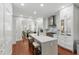 Open-concept kitchen boasts white cabinets, stainless steel appliances, a center island, and hardwood floors for a modern and airy feel at 44 Savage St, Charleston, SC 29401