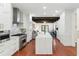 Spacious kitchen with an island features stainless steel appliances, white cabinets, hardwood floors, and modern fixtures at 44 Savage St, Charleston, SC 29401