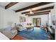 Bright living room with exposed wood beams, neutral-toned seating, stylish blue rug, and double french doors for natural light and access at 44 Savage St, Charleston, SC 29401