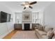 Living room with fireplace, TV, a cozy sofa, and natural light from shuttered windows at 44 Savage St, Charleston, SC 29401