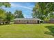 Rear view of a brick residence showcasing a spacious, verdant lawn and access points for easy outdoor enjoyment at 4432 Logwood Drive, Ladson, SC 29456
