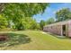Expansive backyard with lush green lawn, mature trees, and a brick exterior creating a private outdoor space at 4432 Logwood Drive, Ladson, SC 29456