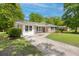 Inviting brick home with crisp white trim, black shutters, and a concrete driveway leading up to the entrance at 4432 Logwood Drive, Ladson, SC 29456