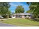 Traditional brick home featuring classic shutters and a lush front lawn with mature trees on a sunny day at 4432 Logwood Drive, Ladson, SC 29456