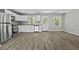 Kitchen with stainless steel appliances, white cabinetry, and wood-look flooring; open to living space at 4432 Logwood Drive, Ladson, SC 29456