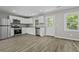 Modern kitchen featuring stainless appliances, white cabinets, granite counters, and wood-style flooring at 4432 Logwood Drive, Ladson, SC 29456