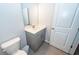 Bathroom featuring gray tile flooring, toilet, and a vanity with a framed mirror at 4577 Summey St, North Charleston, SC 29405