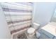 Bathroom with a striped shower curtain, toilet, and vanity with gray cabinetry at 4577 Summey St, North Charleston, SC 29405