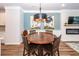 Cozy dining area featuring a round wooden table, modern lighting fixture, and elegant wall art at 4577 Summey St, North Charleston, SC 29405