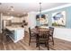 Open concept dining room with round table, stylish lighting, and stainless steel kitchen in background at 4577 Summey St, North Charleston, SC 29405