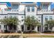 Modern townhome exterior with light gray siding, large windows, and decorative trees enhancing curb appeal at 4577 Summey St, North Charleston, SC 29405