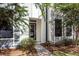 Close up of the front door with sidelight windows, light gray siding and decorative trees at 4577 Summey St, North Charleston, SC 29405