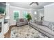 Inviting living room with comfortable sofas, large windows, and a stylish ceiling fan for a relaxing ambiance at 4577 Summey St, North Charleston, SC 29405