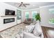 Cozy living room boasts a white brick fireplace, plush gray seating, and a stylish ceiling fan at 4577 Summey St, North Charleston, SC 29405