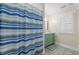 Bathroom featuring a blue vanity, shuttered window, and shower with striped curtain at 478 Commonwealth Rd, Mount Pleasant, SC 29466