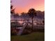 Peaceful morning view of the private dock on a waterway, shrouded in mist and bathed in the soft glow of sunrise at 478 Commonwealth Rd, Mount Pleasant, SC 29466