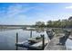 Close up on a private dock with boat lift and attached skiff at 478 Commonwealth Rd, Mount Pleasant, SC 29466
