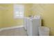 Bright laundry room features shelving, a window with shutters, and a front load washer and dryer at 478 Commonwealth Rd, Mount Pleasant, SC 29466