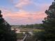 Scenic view of a peaceful waterway, docks, and the surrounding lush landscape at dusk at 478 Commonwealth Rd, Mount Pleasant, SC 29466