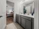Bathroom with double vanity, gray cabinets, and doorway view into bedroom at 484 Trotters Ln, Moncks Corner, SC 29461