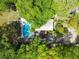 Aerial view of a house with a large in-ground pool and surrounded by lush trees at 4869 Slans Island Rd, Hollywood, SC 29449
