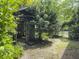A wooden shed sits nestled amongst lush greenery in this backyard at 4869 Slans Island Rd, Hollywood, SC 29449