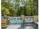 Deck area overlooking fenced pool and lush green trees; outdoor seating included at 4869 Slans Island Rd, Hollywood, SC 29449
