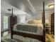 Cozy main bedroom featuring a four-poster bed, soft lighting, and a door leading to the outdoors, offering serene comfort at 4869 Slans Island Rd, Hollywood, SC 29449