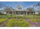 Inviting clubhouse exterior with manicured front yard and covered porch featuring comfortable seating at 5049 Song Sparrow Way, Summerville, SC 29483