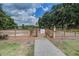 Horse stable entrance featuring fenced areas, and a well-kept gravel path, all surrounded by lush greenery and trees at 5049 Song Sparrow Way, Summerville, SC 29483