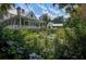 Beautiful backyard exterior of a home featuring lush gardens, a covered porch, and picturesque landscaping and buildings at 5049 Song Sparrow Way, Summerville, SC 29483