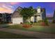 Charming home featuring stone accents, a two-car garage, manicured lawn, and a neatly landscaped front yard at 5049 Song Sparrow Way, Summerville, SC 29483