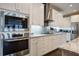 Well-equipped kitchen with stainless steel appliances, granite countertops, white cabinets and tiled backsplash at 5049 Song Sparrow Way, Summerville, SC 29483