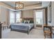 Cozy main bedroom with tray ceiling, carpet, a king bed, multiple windows, and neutral decor at 5049 Song Sparrow Way, Summerville, SC 29483