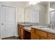 Bathroom with dual granite-topped vanities, large mirror, wood cabinets, and decorative sconces at 505 Eastern Isle Ave, Summerville, SC 29486