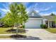Well-maintained home showcasing a wide driveway, two-car garage, and landscaped lawn with blue skies overhead at 505 Eastern Isle Ave, Summerville, SC 29486