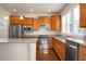 Well-lit kitchen featuring wooden cabinets, stainless appliances, granite countertops, and hardwood floors at 505 Eastern Isle Ave, Summerville, SC 29486