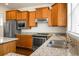 Granite counters, and stainless steel appliances adorn this kitchen, complete with wooden cabinets and wood floors at 505 Eastern Isle Ave, Summerville, SC 29486