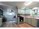 Bright kitchen featuring modern appliances, stylish backsplash and sage green cabinets at 5452 E Lakeland Dr, North Charleston, SC 29406