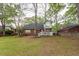 The house's backyard view features a brick home, a green lawn, and mature trees at 5496 Clearview Dr, North Charleston, SC 29420