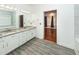 Bathroom with a double sink vanity, marble countertop, and a doorway to a large closet at 5496 Clearview Dr, North Charleston, SC 29420