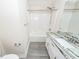 Bathroom with granite topped vanity, and a shower-tub combination with bright white tile at 5496 Clearview Dr, North Charleston, SC 29420